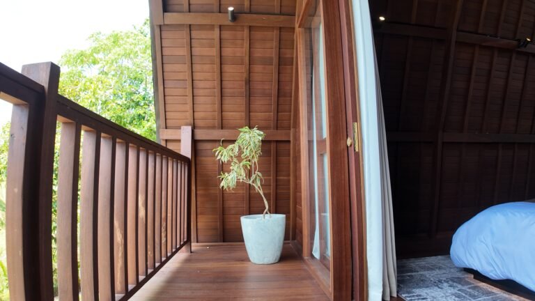 View of the private wooden balcony attached to The Mahaloka's king loft bedroom, with potted plant.