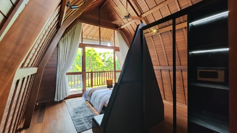 View from beside the bed in The Mahaloka loft, looking towards the open balcony doors and the integrated wardrobe unit.