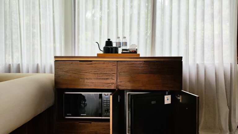 The refreshment corner unit at The Mahaloka with the mini-fridge door open, showing interior alongside the microwave.